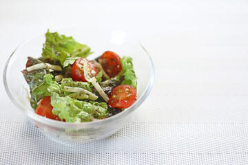 ガラスの器に盛られた刻みチーズトッピングの野菜サラダ