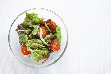ガラスの器に盛られた刻みチーズトッピングの野菜サラダ