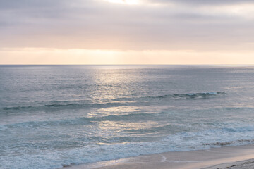 Fototapeta premium Ocean views and sunset. Sun rays make their way through clouds and illuminate the ocean