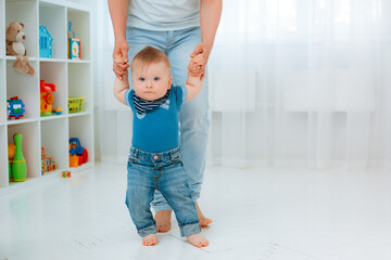 Baby taking first steps with mother's help at home