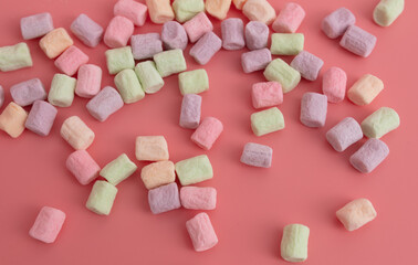 Multicolored candies on a pink background. Close-up