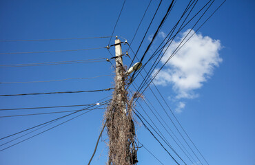 Electric pole with wires against the sky.