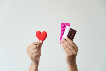 Many colorful pills and red heart shape in woman hands. Health care and medical concept. Good heart...