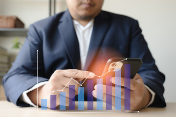 Businessman reading data analysis and pointing finger on mobile phone graph trending up at front.