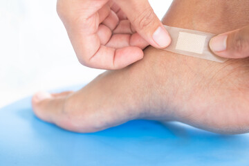 Hand woman close Medical plaster to foot. accident knife wound on leg. safety and first aid for good health concept.