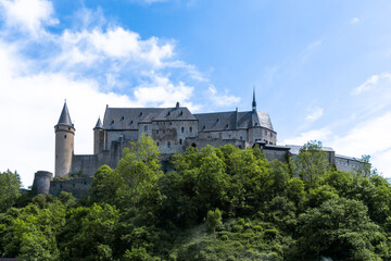 Fototapeta na wymiar the historic Vianden Castle in Luxembourg in midst of lush green summer forest