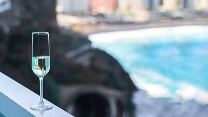 Champagne glass on balcony in luxury tropical hotel with spectacular sea view. vacation and relax concept