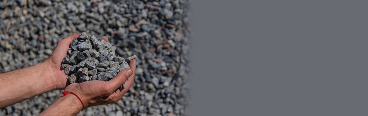 Crushed stones in the hands of a man. Selective focus.