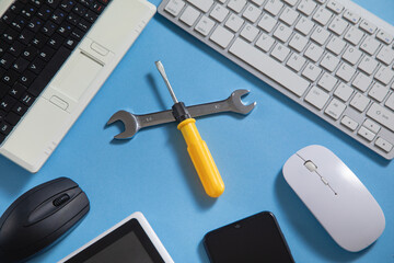 Wrench and screwdriver with a computer keyboard, smartphone, tablet, mouse. IT Service. Support