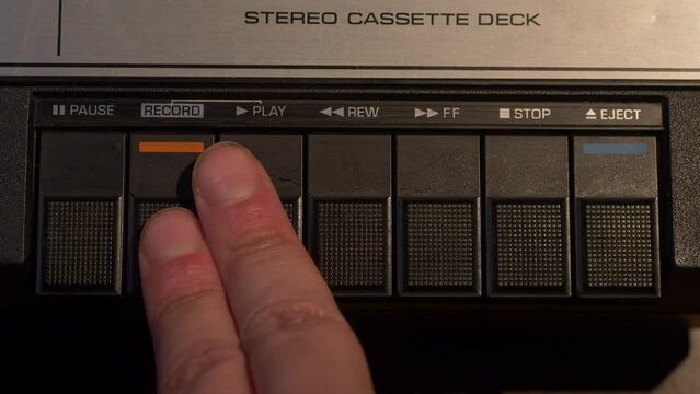 Shot of inserting a tape and pushing the record button on a vintage cassette tape player
