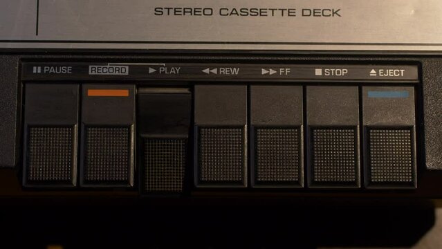Shot of pushing different buttons on a vintage cassette tape player, then ejecting the tape