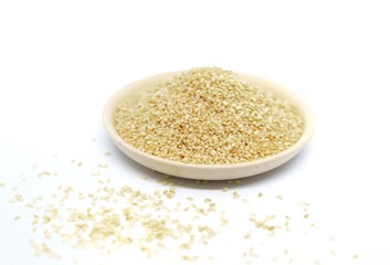 white sesame seeds in a plate on a white background