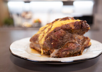 Appetizing meat baked with cheese crust on a plate in the kitchen