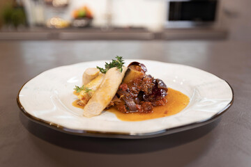 Appetizing vegetable stew with pasta on a plate in the kitchen
