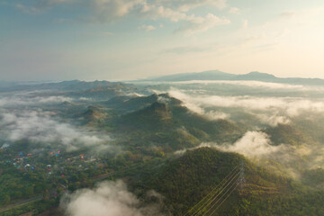 Fog in the morning forest with green mountains and high voltage pole. Pang Puay, Mae Moh, Lampang, Thailand.