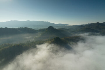 Fototapeta na wymiar Fog in the morning forest with green mountains. Pang Puai, Mae Moh, Lampang, Thailand.