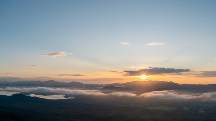 Aerial view Beautiful  panorama of morning scenery Golden light sunrise And the mist flows on high mountains forest and lake. Pang Puai, Mae Moh, Lampang, Thailand.	