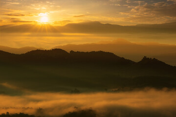 Beautiful fog and golden light in the morning forest with green mountains. Baan Jabo, Mae Hong Son, Thailand.