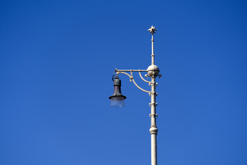 Top of metal street light pole with ornaments at Middle Rhine Bridge at City of Basel on a sunny spring day. Photo taken May 11th, 2022, Basel, Switzerland.