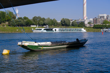 Fototapeta premium Moored wooden boat at Johanniter Bridge on Rhine River at City of Basel on a sunny spring day. Photo taken May 11th, 2022, Basel, Switzerland.
