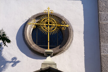 Close-up of golden cross at white apostolic church at the old town of Basel on a sunny spring day. Photo taken May 11th, 2022, Basel, Switzerland.