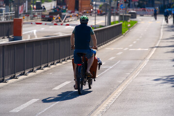 Father with cargo bike transporting own child on a sunny spring day at City of Basel. Photo taken May 11th, 2022, Basel, Switzerland.