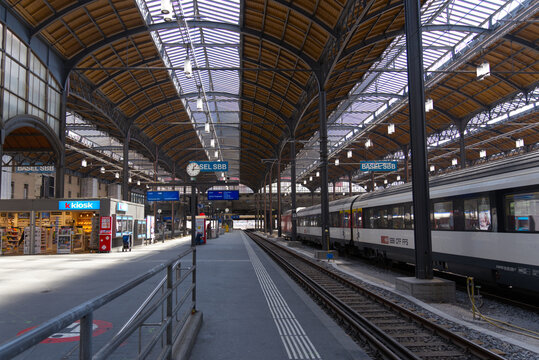 Railway station Basel SBB with platforms and signs on a blue cloudy spring day. Photo taken April 27th, 2022, Basel, Switzerland.
