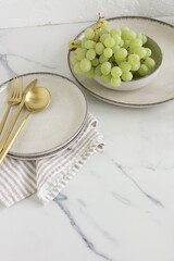 Modern ceramic tableware top view on marble table. Trendy plates, cutlery and linen napkins scandinavian style.Space for text or menu . Business food brand template.