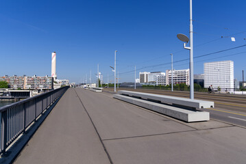 Bridge named Dreirosenbrücke with tramway and chimney of incineration plant in the background at City of Basel on a sunny spring day. Photo taken May 11th, 2022, Basel, Switzerland.
