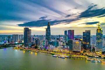 Aerial view of beautiful skyscrapers along the river at sunset sky light flowing down urban development in Ho Chi Minh City, Vietnam.