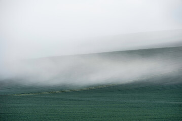 Beautiful vibrant landscape image of sea of fog rolling across South Downs English countryside...