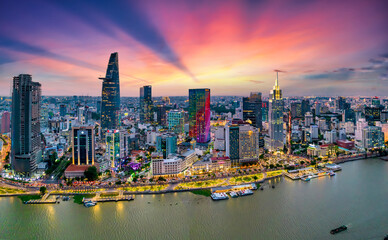 Aerial view of beautiful skyscrapers along the river at sunset sky light flowing down urban development in Ho Chi Minh City, Vietnam.