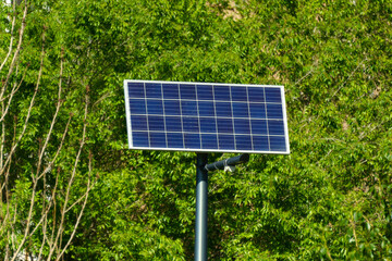 Solar panel on the background of green trees. Ecological energy of renewable solar panels