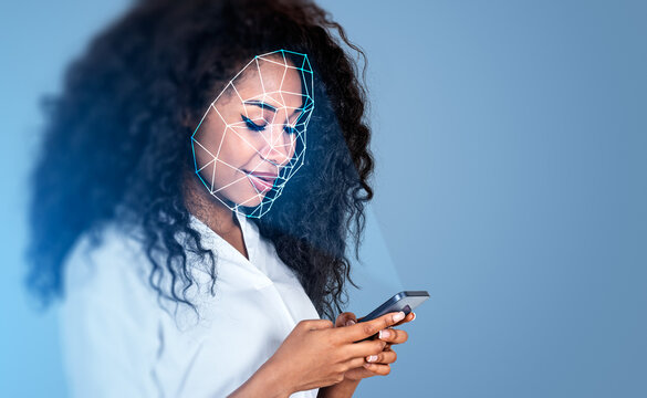 Black businesswoman with smartphone, using facial scanner smiling