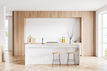 Light kitchen interior with island and seats, shelves and kitchenware, window