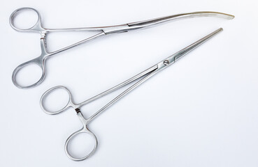 Hand-held medical instrument on a white background.Surgical forceps. Clips for the surgeon. Chrome-plated medical instrument. © Svetliy