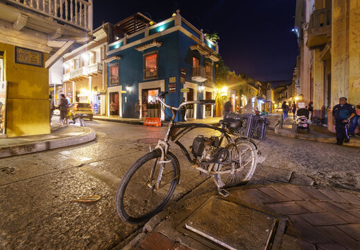 Cartagena, Colombia - May 11 2022: An old artisanal motor bicycle lies in the Cartagena de Indias spanish colonial old town in Colombia at night.