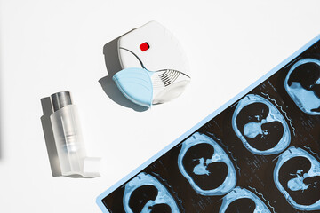 Some asthma inhalers and CT scan of the lungs on white table. Aerosol for inhalation for treat lung inflammation and prevent asthma attack. - obrazy, fototapety, plakaty