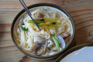 Noodle Soup with seafood is made by boiling thin noodles with seafood, such as shrimp, octopus, and clam, in a baby clam broth.