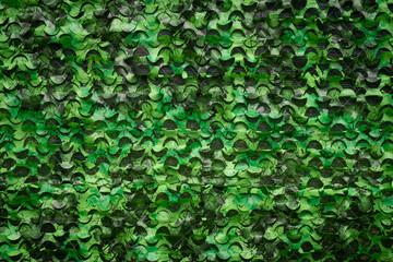 Military camouflage mesh texture background. Dark, brown and green material surface backdrop. Army...