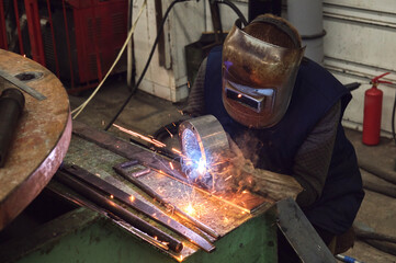 work of a welder, in a chrome welding helmet