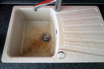 Dirty granite sink with faucet. Brown stains on an artificial stone kitchen sink. Old granite sink top view. acrylic pot sink stained with tea and coffee.