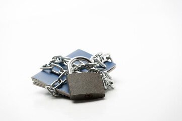 several passports locked with a chain and padlock lying on a white background