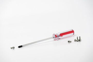chrome screwdriver and several screws on a white background