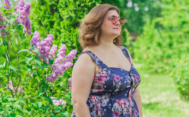 Plus size European or American woman at nature in blue romantic dress, enjoy the life, walks. Life of people xl size, happy nice natural beauty woman. Concept of overweight