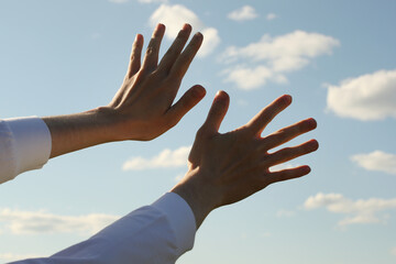 Young man hands and sky with clouds. Photo was taken 22 May 2022 year, MSK time in Russia.