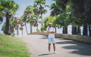 Young traveler man at summer holiday vacation with beautiful palms and seascapes at background