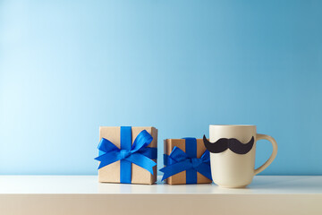 Father's day concept with coffee cup, mustache and gift box over blue background