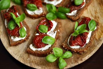 Bruschetta with dried tomatoes and basil. Open sandwiches on rye bread with tomatoes.