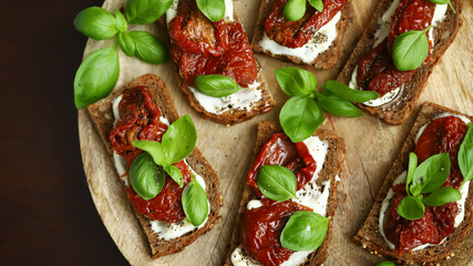 Bruschetta with dried tomatoes and basil. Open sandwiches on rye bread with tomatoes.